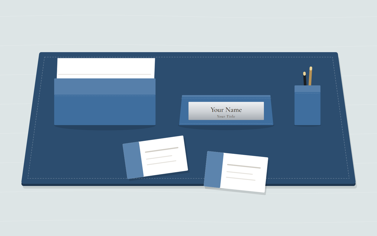 Illustration: a blue desk pad with a large business card holder full of cards, a nameplate with a silver plate and a pen cup, and two business cards lying in front