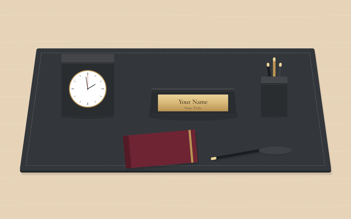 Illustration: a black desk pad with a desk clock, a nameplate with a gold plate and a pen cup, and in front a closed burgundy notebook, a pen and a coaster